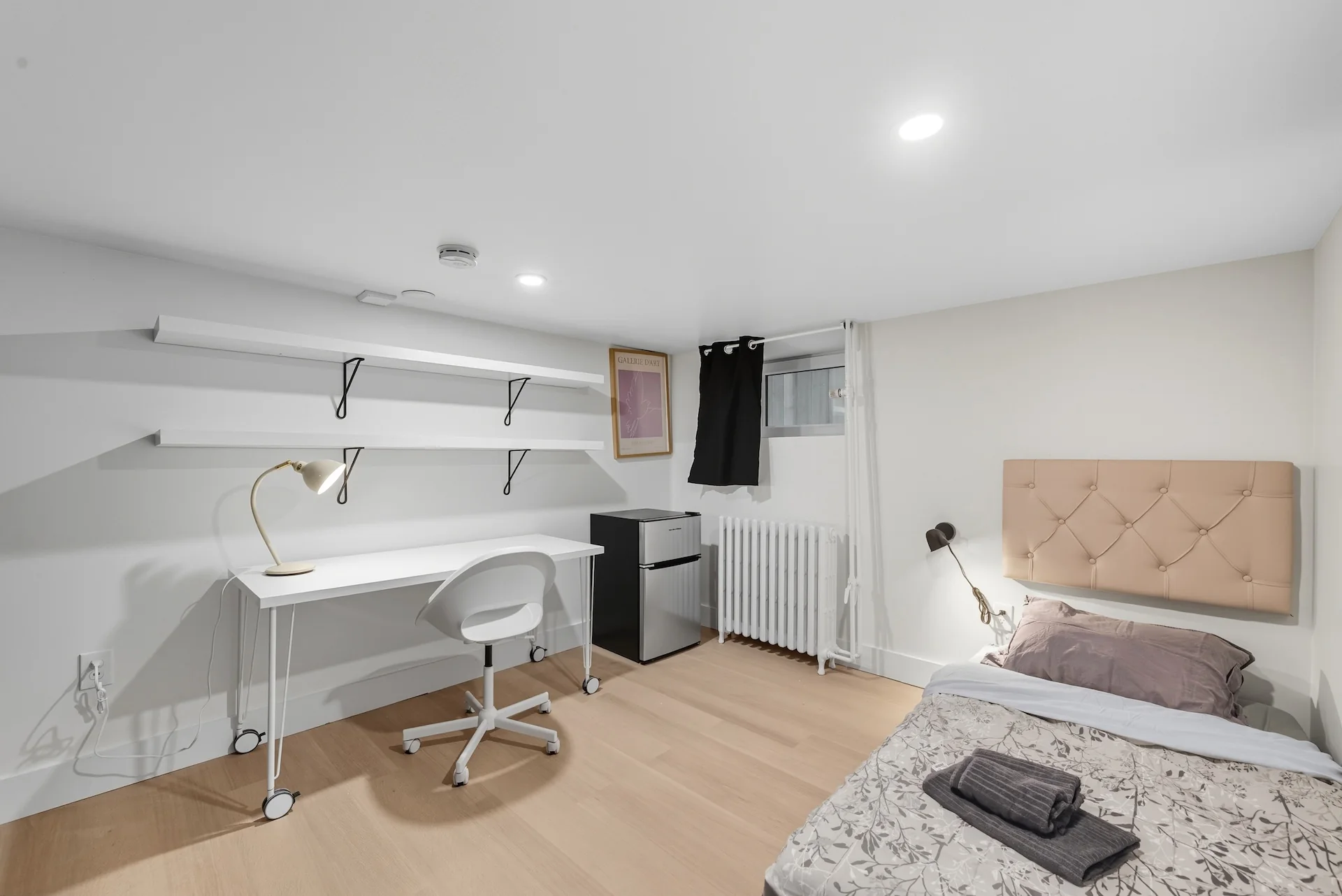 Room example with pale headboard, desk, and shelving